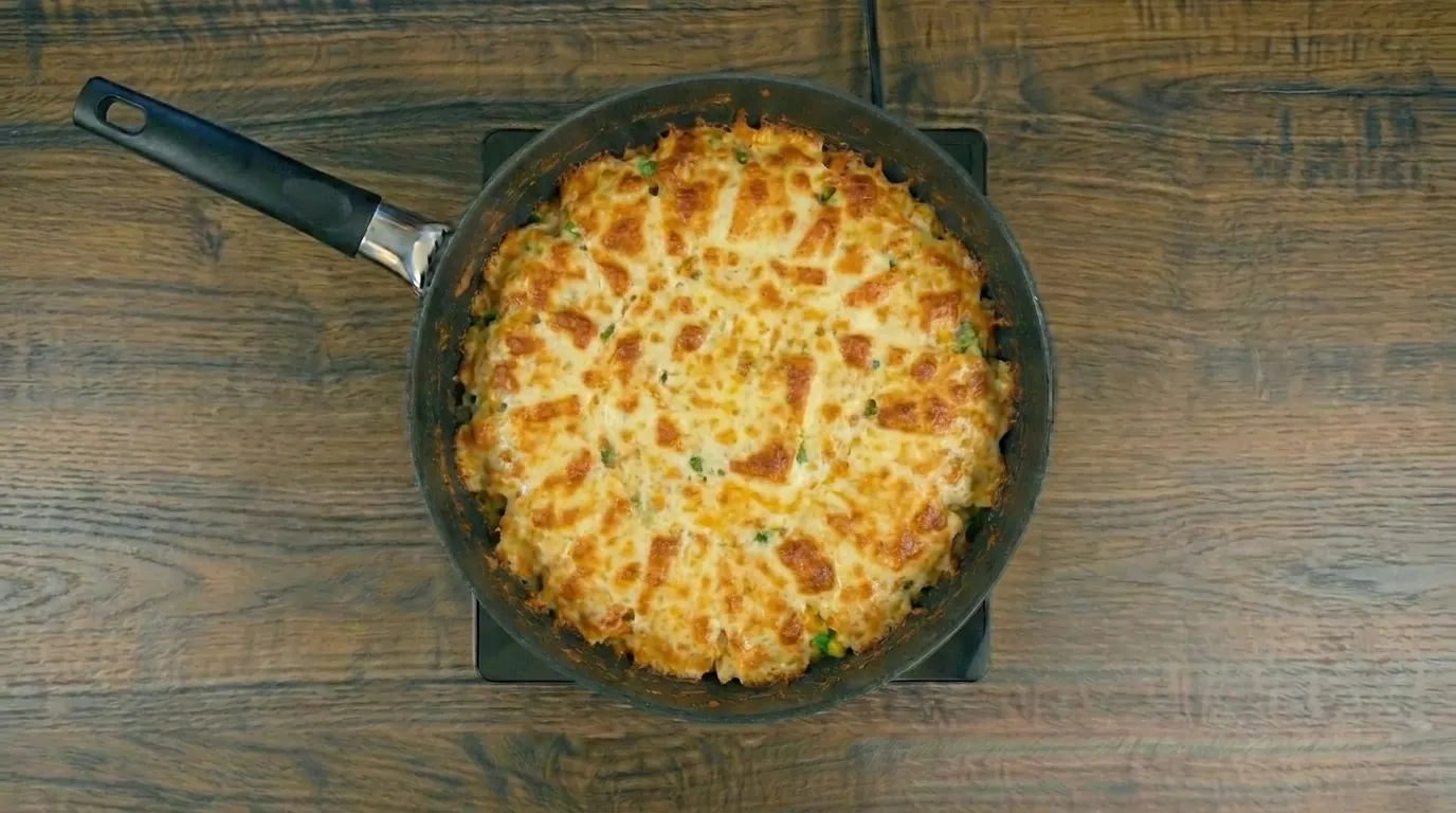 Arroz cremoso na frigideira servido com queijo derretido