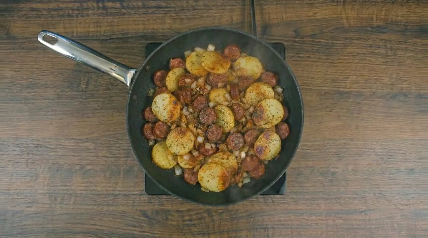 Batata com linguiça na frigideira dourada e servida quente