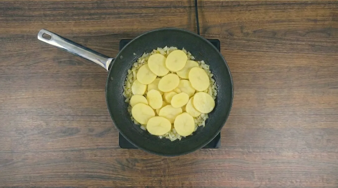 Omelete de batata na frigideira dourada e servida quente
