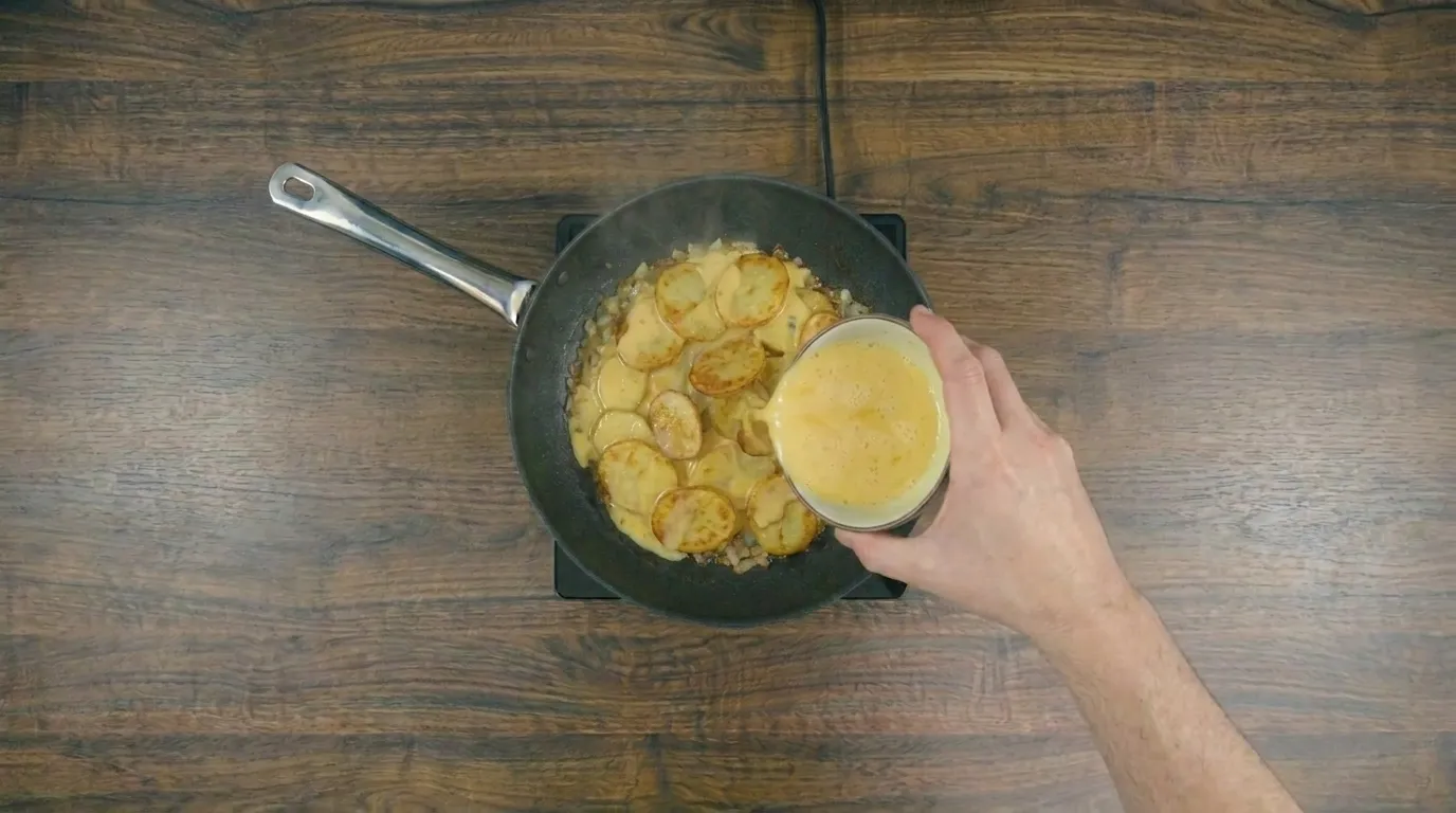 Omelete de batata na frigideira dourada e servida quente