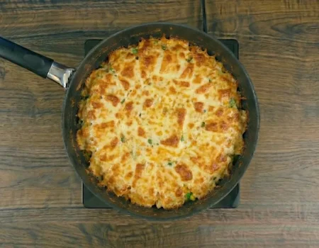 Arroz cremoso na frigideira servido com queijo derretido